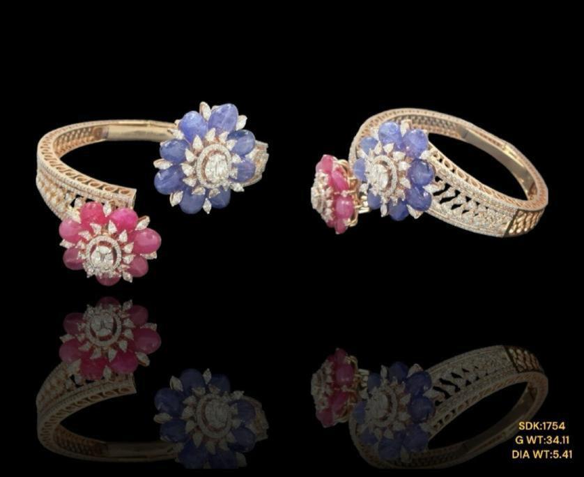 Elegant 14kt gold braclet showcasing a radiant ruby and tanzanite framed by shimmering diamonds