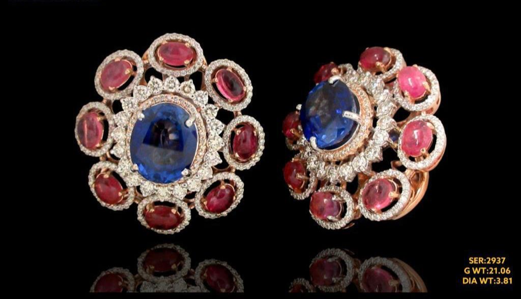 Vibrant ruby and sapphire surrounded by sparkling diamond set in timeless 14kt gold